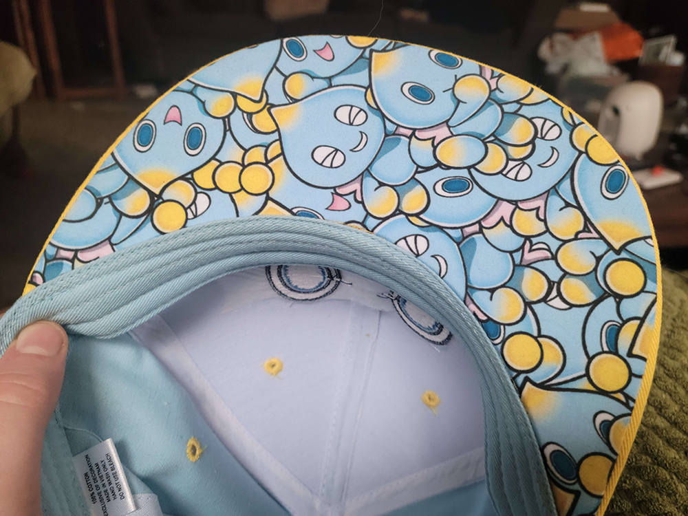 the bottom side of the brim has art of dozens of chao printed